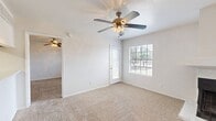 This 1-bedroom, 1-bathroom unit offers a practical and comfortable layout across a single floor. The living room serves as the centerpiece of the space, featuring soft carpeting, a ceiling fan with light fixture, and a standout corner fireplace with a sleek tile surround — an eye-catching architectural detail that adds warmth and character. Natural light filters in through windows fitted with blinds, and a door provides direct access to the private balcony. The living area flows openly toward the dining space and kitchen, which is accessible via a pass-through counter. The kitchen is equipped with gray cabinetry, a stainless steel refrigerator, electric range, stainless sink, and wood-look flooring, providing a clean and functional cooking environment. A pantry offers additional storage. The bedroom is generously sized, with plush carpeting, a ceiling fan, a window with outdoor views, and access to a closet. A second closet provides extra storage elsewhere in the unit. The bathroom includes a full tub and shower combination with chrome fixtures. Ceiling fans are present in both the living room and bedroom, enhancing comfort throughout the home.
