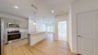 Located at 510 Cedar Tree Rd in Wellford, SC, this well-appointed single-story home offers three bedrooms, two bathrooms, and a thoughtfully designed open-concept layout. The heart of the home is a bright kitchen and living area, where light hardwood flooring flows seamlessly underfoot. The kitchen features gray shaker cabinetry, a white subway tile backsplash, stainless steel appliances, and a central island with a granite countertop and pendant globe lighting overhead. The living area extends naturally from the kitchen and opens to an outdoor balcony through French doors, with a ceiling fan adding comfort to the space. The generously sized primary bedroom features plush carpeting, a ceiling fan, and a walk-in closet with wire shelving. Additional bedrooms are carpeted and receive natural light through windows with views of the surrounding greenery. The bathrooms are finished with granite-topped gray vanities and hardwood-style flooring; the primary bath includes a sleek glass-enclosed walk-in shower. Six closets throughout the home provide ample storage, and a dedicated laundry area adds everyday convenience. Clean white walls and recessed lighting lend the entire home a fresh, modern ambiance.