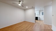 This compact yet efficiently designed 1-bedroom, 1-bathroom single-story residence offers a thoughtfully laid-out floor plan that maximizes every square foot. Warm honey-toned hardwood-style flooring flows consistently throughout the entire unit, creating a cohesive and inviting atmosphere.

The living area is bright and open, featuring a ceiling fan with integrated lighting, recessed lighting, and a modern front entry door with frosted glass panels that allow natural light to filter in. A large window alongside the entry door frames views of the surrounding greenery, further enhancing the airy feel of the space.

The kitchen is well-equipped with shaker-style cabinetry in a soft grey finish, white quartz countertops, a stainless steel pull-down faucet, and black appliances including a dishwasher. A window above the sink provides natural light and outdoor views, making the kitchen both functional and pleasant.

The bedroom is comfortably sized, featuring a ceiling fan, a window with outdoor views, and a closet with sliding doors offering built-in shelving and hanging space. The bathroom is clean and simply appointed, featuring a soaking tub, hardwood-style flooring, and brushed nickel hardware accents. The overall design is modern, minimal, and move-in ready.