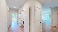 Located at 437 Cold Brook Dr in Sudbury, Massachusetts, this thoughtfully designed single-floor residence offers a clean, modern aesthetic throughout. Light-toned hardwood flooring flows seamlessly across the open-concept living and kitchen areas, creating a cohesive and airy feel. The spacious living area is bathed in natural light from oversized windows and sliding glass doors that frame lush, wooded views and open to an outdoor deck, bringing the tranquility of the surrounding landscape indoors.

The kitchen is a standout, featuring warm natural wood cabinetry, crisp white quartz countertops, a large center island with an integrated sink, and a full suite of stainless steel appliances including a gas range, built-in microwave, refrigerator, and dishwasher. A contemporary linear pendant light anchors the island, adding a polished touch.

The hallway connects bedrooms and utility spaces with ease, highlighted by Shaker-style doors with matte black hardware. Bedrooms are well-proportioned with ample closet storage. The bathroom is elegantly appointed with a dual-sink vanity, wood-toned cabinetry, white quartz counters, large mirrors, and a walk-in shower. An in-unit washer is conveniently tucked within the hallway, completing this well-equipped, move-in-ready home.