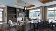This thoughtfully designed single-floor space showcases a sophisticated contemporary aesthetic throughout. The main living area immediately draws the eye upward to its striking tray ceiling, which is accented with warm recessed lighting and a bold geometric pendant light that serves as a dramatic focal point. Built-in dark cabinetry and shelving line one wall, framing a central fireplace adorned with a mosaic tile surround and providing ample display space for decorative accents. A flat-screen television is seamlessly integrated into the built-in unit, enhancing the room's functionality. Large windows along the opposite wall flood the space with abundant natural light and offer serene views of the surrounding greenery, creating a bright and inviting atmosphere. Elegant sheer curtains frame the windows, softening the natural light while maintaining an open feel. The living area is furnished with plush, neutral-toned seating arranged around a patterned area rug, striking a balance between comfort and style. A sleek console table positioned near the windows provides additional surface space and display opportunities. The overall ambiance is polished and refined, blending modern design elements with warm, welcoming touches throughout.