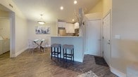 This single-story residence offers a thoughtfully designed layout that balances functionality and comfort throughout its well-defined living spaces. The open-concept kitchen serves as a central hub, showcasing white shaker cabinetry, a mosaic tile backsplash, stainless steel appliances, and a peninsula with bar seating for two — ideal for casual dining or entertaining. Wood-look flooring extends through the kitchen and living areas, lending warmth and visual continuity, while recessed lighting keeps the space bright and inviting. A dedicated dining area accommodates a small table adjacent to the kitchen.

The living room offers a relaxed atmosphere with ample space for a media setup, complemented by wood-look flooring and neutral walls. The primary bedroom features plush carpet, a textured ceiling, natural light from a window with blinds, and direct access to a walk-in closet. A second bedroom mirrors this layout with its own walk-in closet and flexible space suitable as a home office or guest room. Both bathrooms are cleanly finished — one with a white shaker vanity and wood-look flooring, and another with a tub-shower combination. A dedicated laundry room with a full-size washer and dryer completes this well-rounded home.