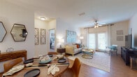 This single-story residence offers a thoughtfully designed open-concept layout that seamlessly connects the dining and living areas, creating a welcoming and functional living environment. The living room features warm hardwood-style flooring, a ceiling fan with light fixture, and large French doors that invite abundant natural light and provide access to an outdoor space. A bold abstract wall painting serves as a focal point, complementing the bright, neutral palette throughout.

The dining area accommodates a round wooden table and flows naturally into the living space, making it ideal for both everyday living and entertaining. The kitchen is outfitted with dark cabinetry, granite countertops, and a full suite of stainless steel appliances, including a refrigerator, electric range, and microwave.

Both bedrooms feature plush carpet flooring and generous windows that fill the rooms with natural light. Each is served by its own full bathroom, both finished with dark vanity cabinetry, granite countertops, tile flooring, and a shower-tub combination.

A dedicated in-unit laundry room includes a full-size washer and dryer alongside built-in shelving, adding a practical and convenient touch to this well-rounded residence.