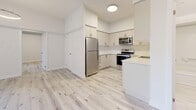 This contemporary 970 square foot apartment in Pickering offers a harmonious blend of style and functionality. The space features two bedrooms, including a primary bedroom of 180 square feet, and one bathroom. The open-concept design seamlessly integrates the kitchen and living areas, creating a spacious feel throughout the single-floor layout.

Light-toned hardwood flooring runs throughout, complementing the crisp white walls and enhancing the apartment's bright, airy ambiance. Large windows, including sliding glass doors leading to a balcony, flood the space with natural light and offer outdoor views.

The modern kitchen is equipped with sleek white cabinetry, stainless steel appliances, and a practical layout. The bathroom showcases a clean, white aesthetic with a combination bathtub and shower unit.

Storage solutions include a dedicated closet and a utility room. The apartment's design emphasizes clean lines and a minimalist approach, creating a canvas for personalized decor. Recessed lighting and ceiling-mounted fixtures provide ample illumination throughout.

Located at 1475 Whites Rd in Pickering, this apartment combines contemporary living with a convenient location, offering a stylish and comfortable home environment.