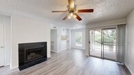 Located at 1595 S Old Orchard Ln in Lewisville, TX, this single-story one-bedroom, one-bathroom unit offers a well-organized layout with clean, modern finishes throughout. Light wood-look flooring runs continuously across the space, complementing the crisp white walls and creating a bright, cohesive feel.

The combined kitchen and living room serves as the heart of the unit. The living area features a striking black tile-surround fireplace, a ceiling fan with light fixture, and a sliding glass door that opens to a private balcony with outdoor views. The kitchen is equipped with stainless steel appliances—including a refrigerator, range, and microwave—white cabinetry, a tile backsplash, and a white countertop pass-through that connects the kitchen to the living space.

The bedroom is a comfortable, well-proportioned room with its own ceiling fan, a window for natural light, and direct access to both the closet and the bathroom. The bathroom features a white vanity with ample cabinetry, a large mirror with Hollywood-style lighting, and wood-look flooring. A dedicated laundry area includes washer/dryer hookups and wire shelving for additional storage. Textured ceilings are found throughout the unit, adding a consistent design element across every room.