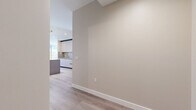 Located at 520 N Central Ave in Glendale, CA, this well-appointed single-floor residence offers three bedrooms and two bathrooms across a generously sized, thoughtfully designed layout. The interior is defined by light-toned hardwood flooring that flows seamlessly throughout, complemented by warm neutral walls and crisp white trim that create a clean, contemporary aesthetic.

The open-concept living and dining area is a standout feature, bathed in natural light through expansive floor-to-ceiling windows. The kitchen is outfitted with modern cabinetry in soft tones, stainless steel appliances, a striking kitchen island with wood-paneled detailing, and track lighting overhead. A set of louvered double doors adds a classic architectural touch near the main living space.

Each bedroom is well-proportioned, offering ample closet space with sliding doors and large windows that invite sunlight throughout the day. The primary bedroom is particularly spacious, providing room for substantial furnishings.

The two bathrooms are finished to a high standard. One features rich brown marble-tiled walls, a soaking tub, glass enclosure, and a walnut-toned vanity. The second bathroom offers a frameless glass walk-in shower with light stone tile, a rainfall showerhead, and a matching walnut vanity with a white quartz countertop. Three hallways provide efficient connectivity throughout the residence.