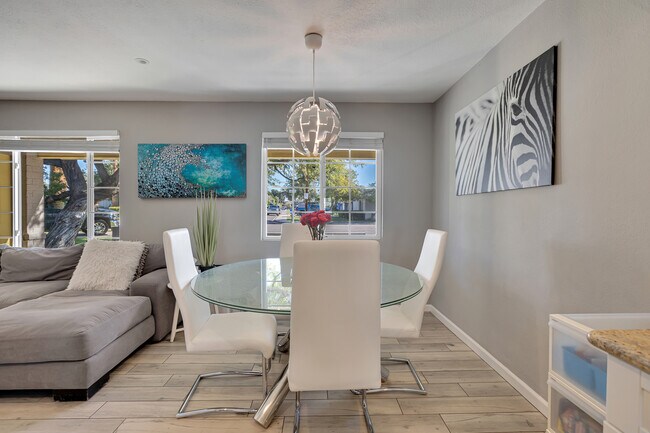 Zona de comedor abierta a la cocina y al salón con iluminación moderna y luz natural. - 6136 N 9th St