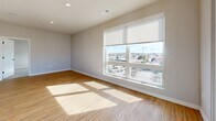 Located at 7831 E Union Ave in Denver, CO, this modern 2-bedroom, 3-bathroom residence offers a thoughtfully designed single-floor layout with a clean, contemporary aesthetic throughout. Light-toned luxury vinyl plank flooring flows through the main living areas, complemented by neutral walls and crisp white trim with sleek black hardware accents.

The open-concept kitchen, dining, and living area serves as the heart of the home. The kitchen is outfitted with white shaker cabinetry, subway tile backsplash, warm wood open shelving, a large center island with quartz countertops, stainless steel appliances, and stylish globe pendant lighting. A barn-style door adds a distinctive design touch nearby.

The primary bedroom is generously sized, featuring plush carpet, a ceiling fan, and a large window with panoramic views of the Denver skyline. It connects to a private en-suite bathroom with a dual-sink vanity, white cabinetry, and a glass-enclosed walk-in shower, plus a spacious walk-in closet with wrap-around hanging rods. The second bedroom is bright and well-proportioned, also with carpet flooring and a large window flooding the room with natural light. Additional spaces include a versatile den, a dedicated laundry room, a utility room, a hallway, and four closets offering ample storage throughout.