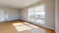 Located at 7831 E Union Ave in Denver, CO, this modern 2-bedroom, 3-bathroom residence offers a thoughtfully designed single-floor layout with a clean, contemporary aesthetic throughout. Light-toned luxury vinyl plank flooring flows through the main living areas, complemented by neutral walls and crisp white trim with sleek black hardware accents.

The open-concept kitchen, dining, and living area serves as the heart of the home. The kitchen is outfitted with white shaker cabinetry, subway tile backsplash, warm wood open shelving, a large center island with quartz countertops, stainless steel appliances, and stylish globe pendant lighting. A barn-style door adds a distinctive design touch nearby.

The primary bedroom is generously sized, featuring plush carpet, a ceiling fan, and a large window with panoramic views of the Denver skyline. It connects to a private en-suite bathroom with a dual-sink vanity, white cabinetry, and a glass-enclosed walk-in shower, plus a spacious walk-in closet with wrap-around hanging rods. The second bedroom is bright and well-proportioned, also with carpet flooring and a large window flooding the room with natural light. Additional spaces include a versatile den, a dedicated laundry room, a utility room, a hallway, and four closets offering ample storage throughout.
