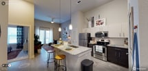 This 728 square foot, one-bedroom apartment showcases a thoughtfully designed open floor plan that maximizes space and functionality. The heart of the home is the sleek, modern kitchen, boasting gleaming stainless steel appliances and expansive granite countertops that provide ample workspace. Pendant lights suspended above the kitchen island add a touch of elegance while illuminating the breakfast bar area, perfect for casual dining or entertaining.

The living area seamlessly flows from the kitchen, creating a spacious feel enhanced by high ceilings and natural light streaming through large windows. Neutral tones dominate the color palette, with light wood-look flooring and white cabinetry contributing to a bright, airy ambiance. Thoughtful decor elements, including framed artwork and decorative objects, add personality to the space.

A ceiling fan in the main living area ensures comfort, while the overall design aesthetic strikes a balance between contemporary chic and cozy practicality. This apartment is ideal for those seeking a modern urban lifestyle in a compact yet well-appointed space.