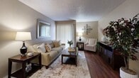 Located at 1301 N Watson Rd in Arlington, Texas, this single-floor, three-bedroom, two-bathroom residence offers a practical and well-organized layout across a comfortable footprint. The living room serves as the heart of the home, featuring rich wood-style flooring, a textured ceiling, and a sliding glass door dressed with vertical blinds that invite natural light into the space. A dedicated dining area adjoins the living room, offering hardwood-style flooring and a cozy, intimate atmosphere. The U-shaped kitchen is equipped with warm wood cabinetry, light speckled countertops, and matching appliances, providing ample storage and counter space for everyday cooking. The primary bedroom is a well-proportioned retreat with carpeted flooring, a bright window, and sliding-door closet access. A dedicated walk-in closet features multi-tiered shelving and hanging rods, offering generous storage. Two additional carpeted bedrooms provide flexible space for guests or a home office. The two bathrooms include a full tub-shower combo with tiled surround and wood-style flooring. Neutral warm-toned walls and textured ceilings carry throughout, creating a cohesive and welcoming ambiance across the entire residence.