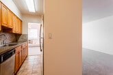 Located at 12 Summit St in West Orange, NJ, this single-floor residence offers a well-organized layout with distinct living, sleeping, and functional zones. The galley-style kitchen is outfitted with warm wood cabinetry, stone-patterned countertops, a tile backsplash, stainless steel appliances including a refrigerator and dishwasher, and light ceramic tile flooring. A window at the end of the kitchen allows natural light to filter through the space.

The living area is generously proportioned, featuring neutral wall-to-wall carpeting, crisp white walls, and multiple windows that bring in ample natural light. Baseboard heating runs along the perimeter, ensuring comfort throughout the space. The layout as seen from above reveals a practical open flow between the main living zone and the adjoining rooms.

The bedrooms are carpeted and well-sized, each with baseboard heating and windows fitted with blinds. One room includes a spacious walk-in closet with wooden shelving and hanging rods, offering substantial storage capacity. The bathroom is finished with classic white tile surrounding the tub-shower combination, accessory grab bars, a vanity with a white countertop, and patterned vinyl flooring. The overall design is clean, functional, and move-in ready.