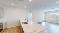 Located at 2966 Linden St in Bethlehem, PA, this well-appointed 3-bedroom, 2-bathroom single-floor home offers a clean, modern aesthetic throughout. Light-toned luxury vinyl plank flooring flows through the main living areas, while plush carpet adds comfort to each bedroom. The open-concept kitchen is a standout feature, boasting striking marble-look quartz countertops with a waterfall peninsula, gray shaker-style cabinetry, recessed lighting, and a full suite of stainless steel appliances including a refrigerator, range, microwave, and dishwasher. The kitchen flows seamlessly into the bright living room, which is filled with natural light from large windows and a glass door leading to a private balcony. The primary bedroom is generously sized with multiple windows and a ceiling fan, while the additional bedrooms feature plush carpeting and garden views. The primary bathroom offers a dual-sink vanity with modern fixtures and a glass-enclosed shower, while the second bathroom includes a tub-shower combination. Three closets provide ample storage. A dedicated laundry area rounds out this thoughtfully designed home.