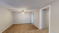 Located at 3863 Memorial Drive in Decatur, GA, this single-floor, 2-bedroom, 1-bathroom home offers a practical and comfortable layout. The open living area is a standout feature, combining hardwood-style flooring and plush carpet, creating a natural division between zones. A ceiling fan with integrated lighting anchors the space, and a window allows natural light to fill the room.

The kitchen is well-appointed with rich, dark espresso cabinetry extending from base to upper wall units, granite-style countertops, a double sink, and a white electric range. A skylight-style ceiling fixture brightens the workspace, while light wood-look tile flooring completes the clean aesthetic.

Both bedrooms are carpeted and feature ceiling fans with lighting and windows that bring in natural light. The second bedroom includes built-in low shelving along one wall, adding a distinctive storage element. A dedicated closet and utility room provide additional storage and functional space.

The full bathroom is finished with a dark wood vanity, white countertop, a wall-mounted mirror, and a tub-shower combination with a curtain rod. Wood-look flooring ties it together with the rest of the home. Textured ceilings are consistent throughout, giving the home a cohesive character. Two hallways connect the rooms efficiently within the compact, well-organized floor plan.