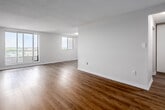 Located on the 11th floor at 433 King St in downtown London, Ontario, this 2-bedroom, 1-bathroom unit offers a thoughtfully arranged single-floor layout with modern finishes throughout. Light-toned laminate flooring flows consistently across every room, creating a clean, cohesive aesthetic.

The spacious living room is a standout feature, bathed in natural light through large sliding windows that frame elevated city views. The kitchen is efficiently designed with crisp white shaker-style cabinetry, granite-look countertops, a stainless steel sink, and stainless steel appliances including an electric range and over-the-range microwave.

The generously sized primary bedroom provides a comfortable retreat with ample natural light from a large window overlooking the cityscape. The second bedroom also benefits from good natural light and includes a mirrored sliding door closet. An additional dedicated walk-in closet with wire shelving on both sides offers exceptional storage capacity. The full bathroom features a white tiled tub-shower combination with chrome fixtures.

The unit is completed by a practical entrance hallway, providing a welcoming transition into the home. Clean neutral walls throughout maintain a bright, airy ambiance well-suited to a variety of interior styles.