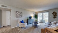 Located at 919 Ballard St in Altamonte Springs, Florida, this single-floor residence offers a well-organized layout designed for comfortable everyday living. The living room serves as the heart of the home, featuring neutral-toned walls, plush carpeting layered over wood-style flooring, a textured ceiling, and a sliding glass door with vertical blinds that allows natural light to filter in and provides access to an outdoor area. The open, inviting atmosphere makes it an ideal space for both relaxing and entertaining.

The galley-style kitchen is thoughtfully designed with white cabinetry lining both sides, ample counter space, a stainless steel sink, and white appliances including an electric range and refrigerator. Wood-style flooring runs throughout this area, adding a clean, cohesive look. Adjacent to the kitchen, the dining area accommodates a round table with seating for four, complemented by wood-style flooring and tasteful wall accents.

The residence includes two bedrooms, each finished with soft carpeting and windows that bring in natural light. The primary bedroom features a walk-in closet, offering generous storage. The bathroom includes a single-sink vanity with white cabinetry and a shower-tub combination, finished with wood-style flooring for a polished, consistent aesthetic throughout the home.
