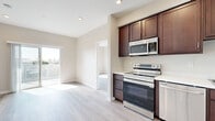 Located at 6916 Fulton St in San Diego, CA, this single-floor unit offers a thoughtfully designed layout with modern finishes throughout. The open kitchen is a central highlight, featuring rich dark-wood cabinetry extending to the ceiling for ample storage, white countertops, and a full suite of stainless steel appliances including an electric range, built-in microwave, dishwasher, and refrigerator. Light wood-style plank flooring runs consistently throughout the unit, contributing to a clean, cohesive aesthetic.

The living area connects naturally to the kitchen and receives generous natural light through a sliding glass door that opens to an outdoor space with neighborhood views. The bedrooms are well-proportioned and sun-drenched, with large windows framing views of the surrounding San Diego community, and include dedicated closet space with built-in rods. 

Two bathrooms maintain the same design language as the rest of the unit, featuring dark-wood vanities with white countertops and wood-style flooring. One bathroom includes a soaking tub with shower, while the second offers a glass-enclosed shower. Neutral wall tones and recessed lighting throughout reinforce the space's clean, contemporary character.