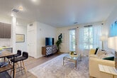 Located at 312 Inverness Way S in Englewood, CO, this well-designed one-bedroom, one-bathroom residence offers a thoughtfully organized single-floor layout with modern finishes throughout. The open-concept living area is filled with natural light streaming through large windows and a glass-paneled balcony door dressed in sheer white curtains, creating an airy, welcoming atmosphere. Light wood-style flooring runs through the main living space, complementing the clean white walls and neutral tones. The kitchen is a standout feature, showcasing rich dark-toned cabinetry, white quartz countertops, a classic subway tile backsplash, and a full suite of stainless steel appliances including a refrigerator, range, microwave, and dishwasher. A small dining area with bar seating provides a functional and stylish dining option. The bedroom offers plush carpeting, a ceiling fan, and large windows overlooking lush greenery, creating a calm and restful retreat with dedicated closet space. The bathroom features wood-look flooring, a dark-cabinet vanity with white countertop, and a tiled soaking tub with shower. Every room reflects a cohesive, contemporary design aesthetic that balances comfort and practicality in an efficient, well-utilized footprint.