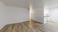 Located at 1302 24th St W in Austin, TX, this single-floor, 2-bedroom, 1-bathroom residence offers a clean and functional layout. Wood-look vinyl plank flooring runs consistently throughout the entire space, lending a cohesive and low-maintenance aesthetic to every room.

The living room is bright and open, with white walls, natural light admitted through a window with blinds, and direct access to the entry door. The space flows naturally toward a kitchen area, which features white cabinetry and a countertop pass-through visible from the main living zone.

Both bedrooms are comfortably sized, with the primary bedroom offering ample space. Each bedroom is equipped with a ceiling fan with a light fixture, a window with blinds for natural light and ventilation, and generous closet space via double sliding-door closets. The clean white walls keep the rooms feeling bright and versatile.

The bathroom includes a full tub and shower combo with white tile surround, chrome fixtures, and grab bars, providing a practical and straightforward design. The overall interior palette of white walls paired with warm wood-tone flooring creates a neutral and inviting atmosphere throughout this efficiently designed Austin residence.