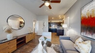 Located at Vantage Pkwy in Fort Worth, TX, this well-appointed one-bedroom, one-bathroom residence offers a smartly designed single-floor layout that maximizes every square foot. The open-concept living area welcomes you with rich wood-style plank flooring, neutral gray walls, and a ceiling fan overhead. Large windows allow natural light to fill the space, while a glass-paneled front door adds an inviting brightness. The living room flows seamlessly into a dedicated dining nook, making the layout feel open and functional. The kitchen is a standout, featuring dark cabinetry, a subway tile backsplash, granite-look countertops, a breakfast bar peninsula, and black appliances — all set atop matching wood-style flooring. The bedroom offers plush carpet, generous natural light through large windows with blinds, and direct access to a dedicated closet. The bathroom is finished with dark wood cabinetry, granite-look counters, wood-style flooring, and a full tub-shower combination with large-format gray tile surround. Throughout the residence, a cohesive design palette of warm neutrals and dark wood tones creates a polished, contemporary ambiance ideal for comfortable everyday living.