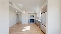 Located at 251 6th St in Sacramento's vibrant Midtown neighborhood, this contemporary 2-bedroom, 2-bathroom residence offers a thoughtfully designed single-level floor plan. The open-concept living, dining, and kitchen area forms the heart of the home, featuring light hardwood-style flooring, recessed lighting, and an abundance of natural light. The modern kitchen is appointed with two-tone cabinetry in white and grey, a white subway tile backsplash, sleek light countertops, and a full suite of stainless steel appliances including a refrigerator, range, microwave, and dishwasher. A window over the sink frames elevated views of the Sacramento skyline. The primary bedroom is carpeted for comfort and receives generous natural light through large windows with open city views. The second bedroom also enjoys sweeping views and offers direct access to a private balcony. Each bedroom is complemented by its own closet with built-in shelving and hanging rods. The bathrooms are clean and contemporary, with one featuring a sliding glass-door walk-in shower with white tile surround and matte black fixtures. A dedicated laundry area and a clean, well-lit hallway complete this efficiently laid-out and move-in-ready residence.