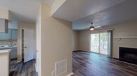 Located at 1510 Bridle Cir in Greenville, NC, this single-floor residence offers a well-designed layout with consistent hardwood-style flooring throughout. The living area is a standout feature, centered around a fireplace with a classic mantle and a ceiling fan overhead. A sliding glass door floods the room with natural light and opens to a private balcony, offering pleasant outdoor views. The textured ceilings add a traditional character to the living and bedroom spaces. The kitchen is equipped with gray shaker-style cabinetry, marble-look countertops, and black appliances including a refrigerator and dishwasher, creating a sleek, functional workspace. The bedrooms are comfortably sized, each with closet storage and their own ceiling fixtures. One bedroom features a built-in closet system, while another benefits from a bright window with natural light. The bathrooms are clean and functional, each featuring a tub-shower combination with chrome fixtures and a white vanity with cabinet storage. The neutral warm-toned walls throughout the unit create a cohesive and inviting atmosphere, making this a practical and comfortable single-floor residence.