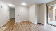 Located at 538 Bond Ave NW, Unit 208 in Grand Rapids, Michigan, this one-bedroom, one-bathroom residence offers a well-designed layout with modern finishes throughout. The open-concept kitchen anchors the living space with rich cherry wood cabinetry, granite countertops, a breakfast bar peninsula with an undermount sink, and a full suite of stainless steel appliances including a refrigerator, range, and microwave. Tile flooring grounds the kitchen area, while warm hardwood-style flooring extends throughout the remainder of the unit, adding a cohesive and polished look. The living and dining areas are bright and open, featuring neutral wall tones and clean lines that create a versatile backdrop for any décor. The bedroom is generously sized, receiving natural light through a large window with views of the surrounding building exterior and balcony railings. A standout feature of the bedroom is the custom built-in closet system, complete with shelving, hanging rods, and a built-in dresser with multiple drawers — providing exceptional storage and organization. The bathroom continues the granite and cherry wood theme, offering a tiled tub-and-shower combination, a vanity with undermount sink, and a large mirror. The unit's consistent finishes and thoughtful layout make it a functional and attractive urban residence.
