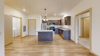Located at 5400 Kingston Lane Northeast in Albertville, MN, this 2-bedroom, 2-bathroom unit offers a thoughtfully designed single-level layout with a comfortable sense of space throughout. The open-concept kitchen serves as the heart of the home, showcasing rich dark cabinetry, granite-style countertops, a center island with pendant lighting, and a full suite of stainless steel appliances including a refrigerator, range, microwave, and dishwasher. Light wood-tone flooring runs through the kitchen and main living areas, lending warmth and continuity to the space. The living area features a ceiling fan, recessed lighting, and a sliding glass door that opens to a private patio with pleasant outdoor views. The spacious primary bedroom includes a walk-in closet with wire shelving and an en-suite bathroom. The second bedroom offers a built-in sliding door closet with easy access to the hallway. Both bathrooms are finished with light wood-tone flooring, vanities with dark cabinetry, and full tub-shower combinations. A dedicated in-unit laundry room houses a full-size washer and dryer alongside additional wire shelving. Soft carpet in the bedrooms and living area adds comfort, while neutral tones throughout create a clean, move-in ready atmosphere.