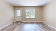 Located at 4172 Bridgewater Pkwy in Stow, Ohio, this 2-bedroom, 1-bathroom residence offers a practical and comfortable single-floor layout. The open living room is bright and welcoming, featuring light wood-look flooring, neutral warm-toned walls, and large sliding windows that fill the space with natural light and offer views of surrounding greenery. A front entry door with a window provides additional light and easy outdoor access. The kitchen is efficiently designed with white cabinetry, wood-accented trim, light countertops, and a Whirlpool electric range with an overhead microwave, all set on durable wood-look flooring. Both bedrooms are carpeted for comfort, with the spacious primary bedroom offering ample room for furnishings and featuring a closet with bi-fold doors. The second bedroom also includes a sliding window, bringing in natural light. The full bathroom is clean and functional, complete with a tub/shower combo, a single-sink vanity, and wood-look flooring. A hallway connects the bedrooms and bathroom, providing a logical and efficient flow throughout the residence. The overall aesthetic is clean, neutral, and move-in ready.