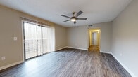Located in Ridgeland, Mississippi, this 2-bedroom, 2-bathroom single-story residence offers a well-organized layout designed for comfortable everyday living. The living room is a welcoming, open space highlighted by durable wood-look flooring, a ceiling fan with light fixture, a textured ceiling, and a large sliding glass door dressed with vertical blinds that fill the room with natural light. A hallway connects the living area to the rest of the home. The galley-style kitchen is efficiently designed with ample gray cabinetry on both sides, light-toned countertops, wood-look flooring, and stainless steel appliances including an electric range and refrigerator. A pendant chandelier illuminates the adjacent dining area. The primary bedroom offers generous proportions, plush carpeting, a ceiling fan, a closet, and direct access to a private bathroom. The second bedroom also features carpeting, a ceiling fan, and a window that brings in natural light. Two hallways guide circulation throughout the home, connecting the bedrooms, bathrooms, and main living spaces. The neutral, warm-toned walls and consistent flooring choices throughout create a cohesive and clean aesthetic, making this a practical and move-in-ready residence.