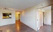 This single-floor residence offers a thoughtfully designed layout that balances comfort and modern style throughout. Rich, dark hardwood flooring flows seamlessly across the main living areas, creating a warm and cohesive aesthetic. The open living space is bright and airy, benefiting from large floor-to-ceiling sliding glass doors that lead to a private balcony, framing views of the surrounding cityscape and greenery beyond.

The kitchen is a standout feature, outfitted with sleek dark cabinetry, granite countertops, stainless steel appliances including a refrigerator, range, and built-in microwave, and a striking mosaic tile backsplash that adds texture and visual interest. A pass-through opening connects the kitchen to the living area, enhancing the open feel of the space.

Additional bedrooms are generously sized, each offering large windows that invite abundant natural light and views of the tree-lined surroundings. French doors provide an elegant transition between areas of the home.

The residence includes two bathrooms. The primary bathroom features a dark-toned vanity with granite countertops, a large mirror with overhead lighting, and a soaking tub with tile surround. The secondary bathroom is finished with light tile flooring and a glass-enclosed walk-in shower. Both bathrooms are clean and well-appointed with quality finishes throughout.