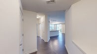Located at 200 Hudson Ct in Wheeling, IL, this well-appointed 2-bedroom, 3-bathroom residence offers a thoughtfully designed single-floor layout with a clean, modern aesthetic throughout. The open-concept living and kitchen area serves as the heart of the home, featuring rich hardwood-style flooring, crisp white cabinetry extending to the ceiling, granite countertops, a peninsula with pendant lighting, and a full suite of stainless steel appliances including a gas range, microwave, dishwasher, and refrigerator. A track lighting system illuminates the kitchen, while a large window in the adjoining living area fills the space with natural light. Both bedrooms are carpeted and offer a comfortable, quiet retreat, with windows overlooking the surrounding neighborhood greenery. The generously sized primary bedroom is served by an en-suite bathroom featuring a dual-sink granite vanity, tile flooring, and a glass-enclosed shower. A dedicated walk-in closet with wire shelving provides ample storage. Two additional bathrooms with tile flooring serve the home. Hallways connect the rooms efficiently, and a dedicated closet adds further storage options. The neutral color palette and consistent finishes create a cohesive, move-in-ready environment throughout.
