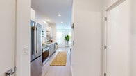 Located at 1658 Lock Ln in Madison, WI, this one-bedroom, one-bathroom unit offers a thoughtfully designed single-floor layout with a clean, modern aesthetic. Light wood-tone flooring runs throughout the space, lending warmth and visual continuity across every room.

The kitchen is well-appointed with stainless steel appliances — including a gas range, built-in microwave, refrigerator, and dishwasher — complemented by two-tone cabinetry featuring white upper cabinets and natural wood-grain lower cabinets. Open wood shelving adds a contemporary touch, while quartz countertops and a single-basin sink complete the functional workspace. Recessed lighting keeps the kitchen bright and inviting.

The open-concept layout connects the kitchen directly to the living area, creating a seamless flow ideal for everyday living. The bedroom is a comfortable retreat, featuring large windows with horizontal blinds that allow ample natural light, a wall-mounted mini-split HVAC unit, and light, neutral walls that enhance the airy atmosphere.

The bathroom showcases a refined design with a wood-grain vanity, white quartz countertop, undermount sink with modern fixtures, a large frameless mirror, and consistent light wood flooring. Clean white walls keep the space feeling bright and fresh throughout.