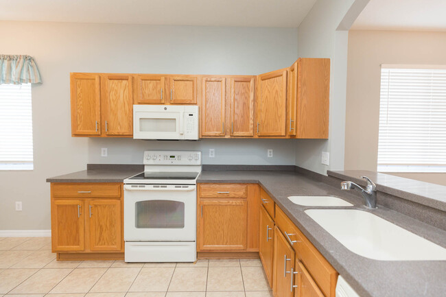 Plenty of cabinetry in kitchen with view into great room - 18135 Nassau Point Dr