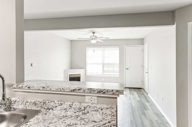 Kitchen with granite countertops, black appliances, white cabinetry, and open breakfast bar overlooking living area - 412 Crossing