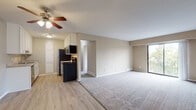 The B3 floor plan at Platinum is a two-bedroom, one-bathroom unit designed with a practical and cohesive layout across a single floor. The open-concept living and dining area serves as the central hub of the unit, featuring plank-style flooring that transitions seamlessly into soft carpeting. A ceiling fan with light fixture overhead provides both comfort and ambient lighting, while a sliding glass door floods the space with natural light and provides access to a private balcony.

The galley-style kitchen is well-appointed with white cabinetry, granite-style countertops, and stainless steel appliances including a refrigerator, electric range, microwave, and dishwasher. Light wood-style flooring and a dedicated pantry cabinet enhance both functionality and storage.

Both bedrooms are carpeted and offer windows that bring in natural light. The primary bedroom features a walk-in closet with a built-in hanging rod, while the second bedroom includes a standard closet with generous space. The shared bathroom is finished with a full-size soaking tub and shower combination alongside neutral-toned walls. Throughout, warm beige tones and clean white trim create a consistent and welcoming aesthetic.