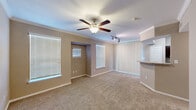 Located at 10498 Fountain Lake Drive in Stafford, TX, this one-bedroom, one-bathroom residence offers a thoughtfully organized single-floor layout. The living area is generously sized, featuring warm neutral-toned walls, plush wall-to-wall carpeting, crown molding, and multiple windows with horizontal blinds that invite abundant natural light. A ceiling fan with integrated lighting and a track lighting fixture add functional illumination throughout the space. A vertical blind-covered sliding door panel provides additional light control and access potential.

The kitchen is well-equipped with rich dark espresso cabinetry, granite-style countertops, hardwood-style flooring, and black appliances including a refrigerator, electric range, microwave, and dishwasher. The galley-style layout maximizes efficiency while maintaining a stylish aesthetic.

The bedroom is a comfortable and quiet retreat, complete with carpeting, a ceiling fan, and a window that allows for natural light. It connects conveniently to the bathroom, which features a tub-shower combination with tiled accents, hardwood-style flooring, and a dark-toned vanity. An adjacent walk-in closet with built-in shelving adds practical storage. A hallway ties the layout together, creating a smooth and functional flow throughout the home.