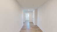 Located in Stevensville, MD, this thoughtfully designed two-bedroom, one-bathroom unit with a den offers a bright, contemporary living experience across a well-utilized single floor. The open living room is bathed in natural light through two large windows that frame picturesque outdoor views, complemented by light-toned hardwood-style flooring that runs throughout the main areas. A sliding glass door leads to a private balcony, further enhancing the connection to the surrounding scenery.

The kitchen is finished with crisp white shaker cabinetry, a classic subway tile backsplash, light countertops, and a full suite of stainless steel appliances including a refrigerator, range, and built-in microwave. The primary bedroom features plush carpeting, generous natural light, and a spacious walk-in closet with built-in shelving. The second bedroom offers a clean, neutral palette with the same quality flooring found throughout.

The bathroom includes large-format tile flooring and a tiled walk-in shower with a sleek, modern finish. A dedicated laundry room houses a stacked washer and dryer unit alongside a water heater, with a window overlooking the marina. A central hallway connects all rooms efficiently, making this a well-organized and functional home.