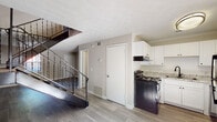 Located at 1055 Holcombe Rd in Decatur, Georgia, this two-floor residence offers a practical and well-organized layout across both levels. The main floor features wood-look luxury vinyl plank flooring throughout, creating a clean, cohesive aesthetic. The open living area is anchored by a bold staircase with dark metal railings and carpet-lined treads, serving as a visual focal point. A textured ceiling adds dimension to the living space.

The kitchen is efficiently designed with white shaker-style cabinetry, granite-look countertops, and black appliances including a range and refrigerator, complemented by a under-cabinet range hood and a single-basin sink. An adjacent door provides convenient access to additional areas of the home.

A full bathroom on the main level features a white vanity with under-cabinet storage, a wall-mounted mirror with overhead lighting, a toilet, and a bathtub with shower. The clean, all-white palette gives the space a bright and functional feel.

Upstairs, the carpeted bedrooms offer comfortable and quiet retreats. One standout bedroom features dual closets with bifold doors, providing ample storage. Natural light filters in through windows fitted with horizontal blinds, and textured ceilings are consistent throughout the upper level. The overall design is clean, move-in ready, and functional.