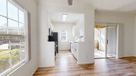 This well-appointed one-bedroom, one-bathroom residence at 455 Dennery Rd in San Diego offers a thoughtfully designed single-floor layout with a clean, modern aesthetic throughout. Light-toned wood-look flooring runs seamlessly across every room, tying the space together with a warm and cohesive feel.

The living room is bright and open, benefiting from natural light through a front-facing window and a ceiling fan overhead. Sliding glass doors lead directly to a private outdoor patio area, enhancing the sense of space and providing easy indoor-outdoor access.

The galley-style kitchen is a standout feature, finished with crisp white cabinetry, marble-look countertops, and stainless steel appliances including a refrigerator and dishwasher. A skylight and arched window allow natural light to fill the space, creating an airy and functional cooking environment.

The bedroom is a comfortable, well-proportioned room with a large sliding-door closet and a window that brings in additional natural light. Its neutral white walls complement the warm flooring for a restful atmosphere.

The bathroom is clean and efficiently laid out, featuring a shower-tub combo, a modern vanity with a marble-look countertop, and consistent wood-look flooring. Every room reflects a fresh, updated interior well-suited for comfortable everyday living in San Diego.