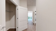 Located in Seattle's vibrant South Seattle neighborhood, this two-bedroom, one-bathroom residence offers a thoughtfully designed single-floor layout. The open-concept kitchen serves as the heart of the home, featuring crisp white shaker cabinetry, a classic subway tile backsplash, stainless steel appliances including a gas range, microwave, and refrigerator, and a generous center island with a built-in sink and bright white countertop — ideal for both meal prep and casual dining. Warm hardwood-style flooring flows throughout the space, complementing the clean, neutral palette on the walls and ceilings. Recessed lighting and a wall-mounted mini-split unit add to the kitchen and living area's modern functionality. The bedrooms are bright and comfortable, with large windows dressed in roller shades that invite natural light and offer views of lush greenery outside. One bedroom includes direct access to a dedicated closet. A well-appointed hallway connects the rooms and reveals a conveniently tucked stacked washer and dryer unit. The bathroom is finished with grey tile flooring and a tub-shower combination enclosed by sliding glass doors and surrounded by white subway tile. The overall ambiance is clean, modern, and move-in ready.