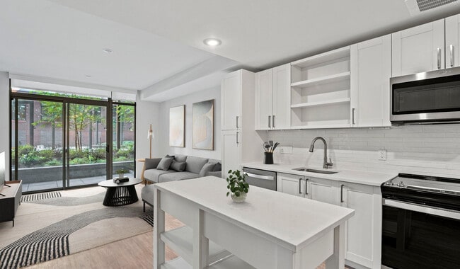 Kitchens equipped with quartz countertops, French door refrigerators, and a large kitchen island will encourage you to whip up your favorite meals - Upton Place Apartments