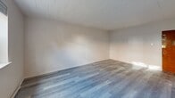 Located at 2049 Brown Ave in Bensalem, PA, this single-floor, 2-bedroom, 1-bathroom unit offers a functional and updated layout across a comfortable footprint. Luxury vinyl plank flooring in a cool gray tone runs consistently throughout the living spaces, lending a cohesive, modern feel.

The kitchen is equipped with white cabinetry, a subway tile backsplash, and white appliances including a refrigerator, electric range, and dishwasher. A ceiling fan with integrated lighting is installed overhead, and the open end of the kitchen connects seamlessly to the adjacent living area, which also benefits from a ceiling fan, wall-unit air conditioning, and windows that bring in natural light.

Both bedrooms are well-proportioned, with the primary bedroom offering generous space. Each room features the same LVP flooring, neutral walls, and windows overlooking the exterior. Baseboard heating runs along the perimeter of the living room and bedrooms, providing consistent warmth. The unit also includes two closets for added storage.

The bathroom is finished with large-format marble-look tile surrounding the tub/shower combination, complemented by tile flooring. Two hallways connect the rooms, and the layout flows efficiently throughout. Warm-toned wood interior doors add a classic contrast to the otherwise light and neutral palette.