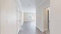 Located at 9807 Gable Ridge Terrace in Rockville, MD, this 2-bedroom, 2-bathroom single-floor residence offers a clean, modern design with a bright and neutral color palette throughout. The entrance flows naturally into the open living and dining areas, where light hardwood-style flooring, crisp crown molding, and large windows with blinds create an airy, welcoming atmosphere. Multiple windows allow abundant natural light to fill the space, with views of surrounding greenery.

The kitchen is well-appointed with white shaker-style cabinetry extending to the ceiling for generous storage, light quartz-style countertops, and stainless steel appliances, including a gas range. The hardwood-style flooring continues seamlessly into the kitchen, reinforcing a cohesive design.

Both bedrooms offer plush carpeting and ample natural light. The spacious primary bedroom provides a comfortable retreat, while the second bedroom is equally bright and functional. Each bathroom is finished with wood-look flooring, a white vanity with modern hardware, a large mirror, and a full tub-shower combination with tiled surrounds.

Hallways connecting the rooms are well-proportioned, and the thoughtful layout ensures a smooth and efficient flow throughout the residence, making it a comfortable and practical living space.