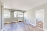 Located at 3730–3736 Kanawha St NW in Washington, DC's desirable Chevy Chase neighborhood, this one-bedroom, one-bathroom residence offers a thoughtfully designed layout across a single floor. Light wood-style flooring runs throughout the entire unit, lending a clean, cohesive aesthetic to every room.

The combined living and dining area is bright and open, featuring large multi-pane windows that invite natural light and offer views of the surrounding neighborhood. A wall-mounted radiator provides efficient heating, and the neutral gray walls create a calm, versatile backdrop.

The kitchen is well-equipped, featuring white shaker cabinetry, granite countertops, a classic white subway tile backsplash, a stainless steel sink with a modern faucet, and black appliances including a gas range and refrigerator. A closet off the kitchen provides additional storage.

The bedroom is a comfortable size, fitted with a ceiling fan with integrated lighting, a window for natural light and ventilation, and a mirrored sliding-door closet for convenient storage.

The bathroom showcases marble-style wall tiles from floor to ceiling, complemented by mosaic tile flooring in the walk-in shower area, delivering a polished, upscale finish. The entry area includes a closet and provides a clean transition into the main living space.