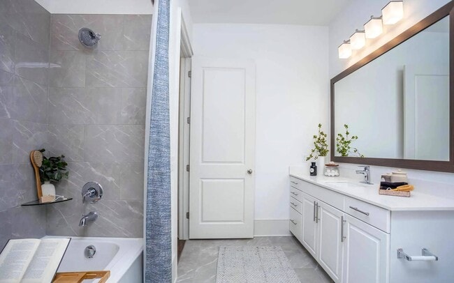 Bathroom Featuring Tile Shower Wall and Extended Countertop with Sink - The Lights at Northwinds