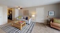 This single-floor residence offers a well-organized layout with multiple bedrooms, a living area, kitchen, and bathroom. The living room is an inviting space featuring wood-look flooring, a textured ceiling, and a ceiling fan. A large sliding glass door fills the room with natural light and provides access to an outdoor area, while neutral-toned walls create a warm, versatile backdrop throughout.

The kitchen is finished with dark cabinetry, granite-look countertops, black appliances, and a mosaic tile backsplash, combining a sleek, modern aesthetic with practical functionality. Each bedroom features plush carpeting, large windows with curtain panels that allow for natural light, and ample closet space. The bedrooms are generously proportioned, accommodating full-sized furniture with ease.

The bathroom includes a full tub-shower combination with white tile surround, wood-look flooring, and granite-look countertop surfaces, maintaining a clean and consistent finish. Throughout the unit, the neutral color palette, textured ceilings, and consistent flooring materials contribute to a cohesive and comfortable living environment suitable for everyday use.
