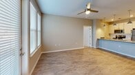 Located at 2051 Establishment Way in Charlotte, NC, this single-floor residence offers a well-designed layout with a neutral color palette and a blend of practical finishes throughout. The main living area features durable wood-look flooring, large windows that invite natural light, and a ceiling fan with a built-in light fixture. Adjacent to the living space, a kitchen with pendant lighting and a raised bar counter provides a seamless transition for everyday living and entertaining.

The bedrooms are carpeted for comfort and feature windows with blinds that offer views of the surrounding area. At least one bedroom includes direct access to a private en-suite bathroom, while a spacious walk-in closet outfitted with multi-tiered wire shelving systems provides generous storage capacity.

The bathrooms are finished with wood-look tile flooring, light-toned cabinetry with brushed nickel hardware, white countertops, and well-lit vanity mirrors. The primary bathroom features a dual-sink vanity, a tiled walk-in shower with elegant stone-patterned tile, and a soaking tub, conveying a clean, contemporary aesthetic. Clean white panel doors and crisp white trim complement the warm beige walls found throughout the residence, creating a cohesive and inviting atmosphere from room to room.