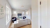 This well-appointed two-floor home combines modern design with comfortable, functional living across its thoughtfully arranged spaces. Light hardwood flooring flows throughout, complementing the neutral warm-gray and white palette that gives each room a clean, cohesive aesthetic.

The main level features an inviting living area bathed in natural light from dual windows, complete with a wall-mounted mini-split system for year-round climate control. Adjacent to it is a cozy dining nook, ideal for casual meals. The kitchen is a standout, outfitted with crisp white shaker cabinets, a classic subway tile backsplash, white quartz countertops, stainless steel appliances, and a central island offering additional prep and seating space. A convenient half bath with a window and natural light completes the main level.

Upstairs, the second floor hosts the bedrooms, each equipped with individual mini-split units for personalized comfort. The primary bedroom is generously sized with closet access and direct views into the bright upper hallway. The full bathroom on this level features a double-sink vanity with framed mirrors, large-format tile flooring, a soaking tub, and a bright window that fills the space with natural light. The upper floor's open layout connects the rooms with ease, creating a practical and serene living environment.