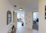 Located in Doral, Florida, this single-floor residence offers a vibrant and thoughtfully designed living experience. The entry hallway welcomes visitors with clean white walls, tile flooring, and an arched decorative mirror, providing glimpses into the living areas and bedrooms beyond.

The open-concept living and dining area is a standout, featuring expansive floor-to-ceiling sliding glass doors that open to a private balcony with sweeping panoramic views of the surrounding Doral landscape. Abundant natural light fills the space, complementing the light tile floors and a bold cobalt blue accent wall in the living room.

The kitchen is well-appointed with dark cabinetry, granite countertops, stainless steel appliances, and pendant lighting, offering both functionality and style. Multiple bedrooms provide versatile accommodations: the primary bedroom showcases a striking cobalt blue accent wall, carpet flooring, a ceiling fan, and large windows with outdoor views; a second bedroom features a vivid orange-red accent wall; and an additional bedroom is configured with bunk beds, ideal for flexible use.

Bathrooms are finished with granite vanity countertops, modern fixtures, light tile flooring, and clean white tiling in the tub-shower areas. Bold navy accent walls in the bathrooms tie together the residence's cohesive, colorful design aesthetic throughout.